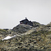 Die winzige Rojacher Hütte; im Hintergrund Nebelschwaden, die immer wieder den Sonnenschein unterbrechen
