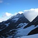 Im Vordergrund ein imposantes Wolkenspiel am Grat des Lagginhorns. Im Hintergrund versteckt sich das Fletschhorn.