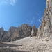 - faul liege ich in der Sonne und gucke zum eindrucksvollen Campanile di Val Strut (3049 m), der vom Gipfelaufbau der Cima dei Bureloni überragt wird.<br />Eine dieser Scharten ist der gleichnamige Passo, auf dem ich vor Stunden stand und hierher ins Val Strut hinunter blickte.