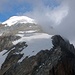 Galengrat und Gipfeleisfeld vom Galenstock. Zwei Personen im Abstieg im unteren Schneefeld. 