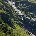 Alpe Piumogna - vom Forno fliesst ein Bach über die Felsen. Oben durch führt die Route Cap. Campo Tencia - Cap. Alpe Sponda über die Bocchetta di Ghiaccaio.