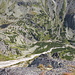 Predné Solisko - Ausblick vom Gipfel hinunter ins Tal Mlynická dolina zum Wasserfall Vodopád Skok sowie zu den ober- und unterhalb gelegenen Seen Pleso nad Skokom (links, groß) bzw. Pliesko pod Skokom (rechts/unterhalb des Wasserfalls, sehr klein).