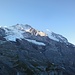 Erste Sonnenstrahlen an Jungfrau und Silberhorn. Ganz links am Bildrand erkennt man die Guggihütte auf dem Felssporn.