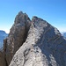 Über plattiges Gelände kann man in anregender Kraxelei zum Cristallino hinüberturnen. Die zunächst etwas furchteinflößende Gipfelscharte erweist sich ebenfalls als vollkommen gutmütig. Im Hintergrund links der Sorapiss, rechts die Vezzana (Palagruppe).