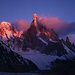 Die ersten Sonnenstrahlen tauchen die Spitze des Bergs in purpurfarbenes Licht.