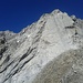 Die kurze Kletterpassage zum Gipfel (Blauer Pfeil).