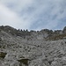 Schotterqualen. Loses Steilgeröll oder dünne Geröllschichten auf steilen Felsplatten. Blick hinauf zu den vier Riffeln (4 Türme am Gipfelgrat), rechts daneben liegt der Gipfel.