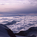 Blick über das wolkenbedeckte Valtellina (Veltlin) beim Aufstieg von der Fuorcla Bellavista zum Piz Palü über den felsigen Westgrat des Piz Spinas.