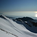 Blick vom Monte Sagro über Schnee und Eis zum Meer, am Horizont sieht man Korsika