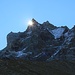 Die Sonne lugt hinter dem Gipfel des Besso hervor