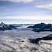 Vom Breithorn-Gipfel bietet sich ein fantastischer Blick nach Norden. Tief unten das wolkenbedeckte Mattertal, flankiert von Weisshorn (4505m, links) und Dom (4545m, rechts). Am Horizont im Zentrum des Bildes die Berner Alpen.