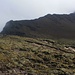 Blick von Gratausläufer zum eigentlichen Westsüdwestgrat, dem Loma Surucho. Der erste Aufschwung wird rechts in der Flanke auf einem Bergweg umgangen. Gegen den Gipfel hin steigt der Grat nochmals steil an, allerdings steckt der Gifelkopf vom Corazón (4782m) gerade in Wolken.