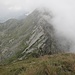 Rückblick aus dem Schlußaufstieg zur Cima della Laurasca auf den Grat. Der Cimone di Cortechiuso ist schon wieder in Wolken gehüllt. Der Sentiero Bove führt durch die Geröllfelder links unterhalb des Grates.